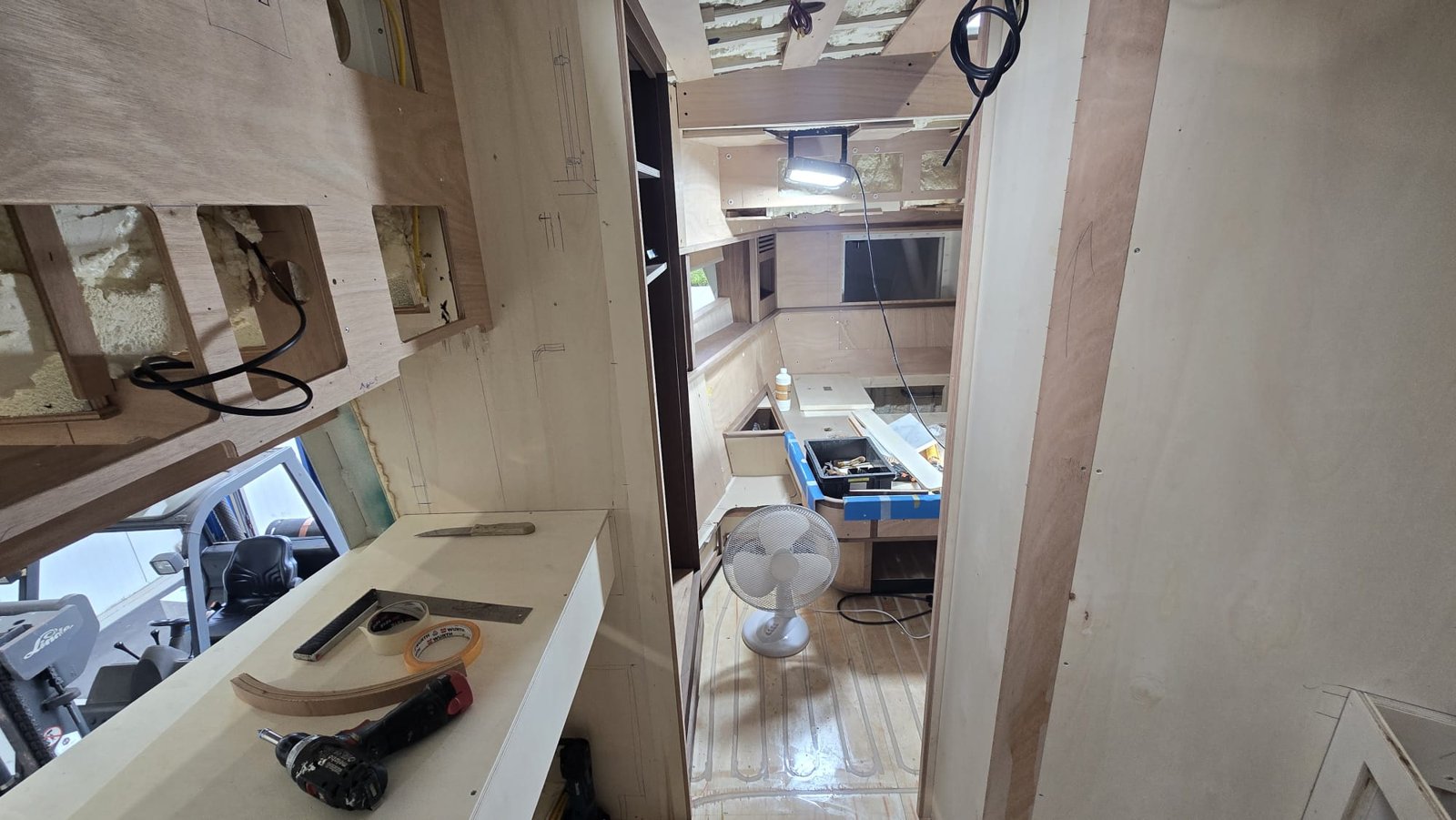 Hut in aanbouw met meubelwerk en zicht naar de kombuis