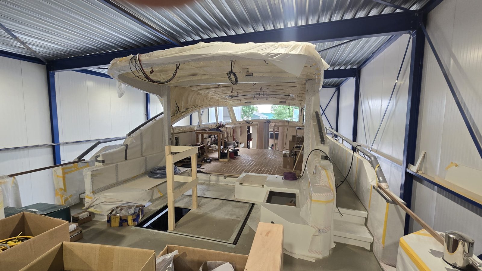 Open kuip en salon in afbouw met geïsoleerd dak en losse bekabeling