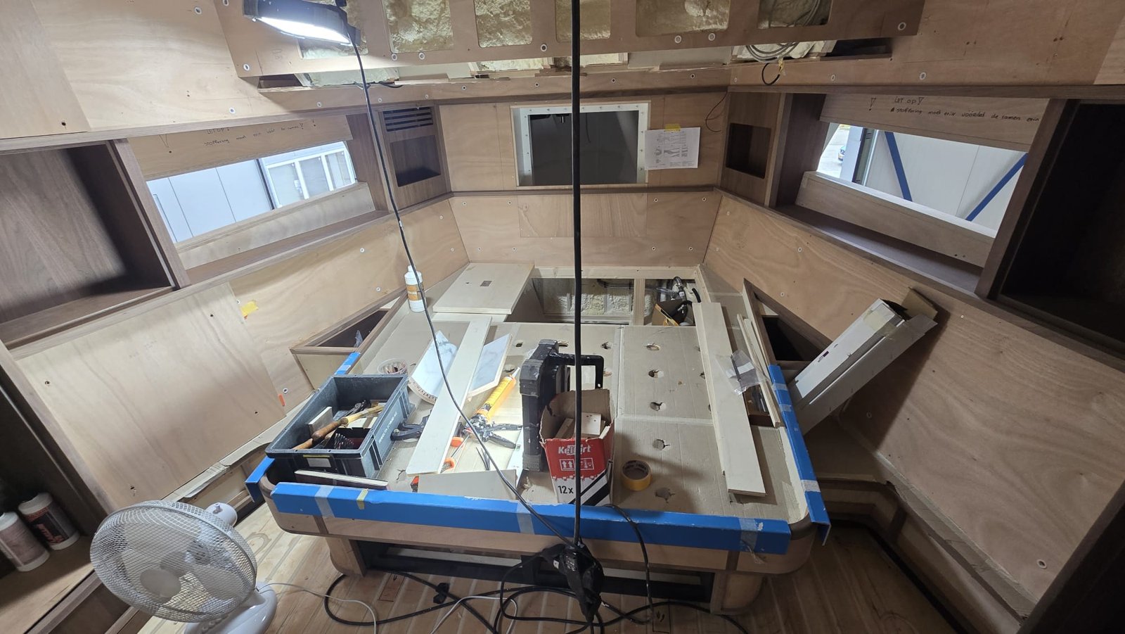Salon in aanbouw met meubelwerk en een tafel vol gereedschap
