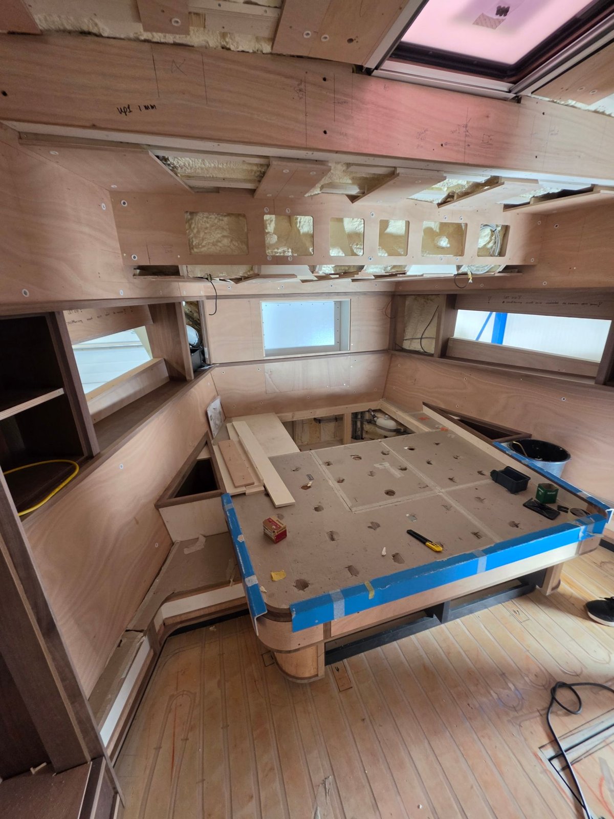 Salon in aanbouw met meubelwerk, geïsoleerde wanden en open plafond
